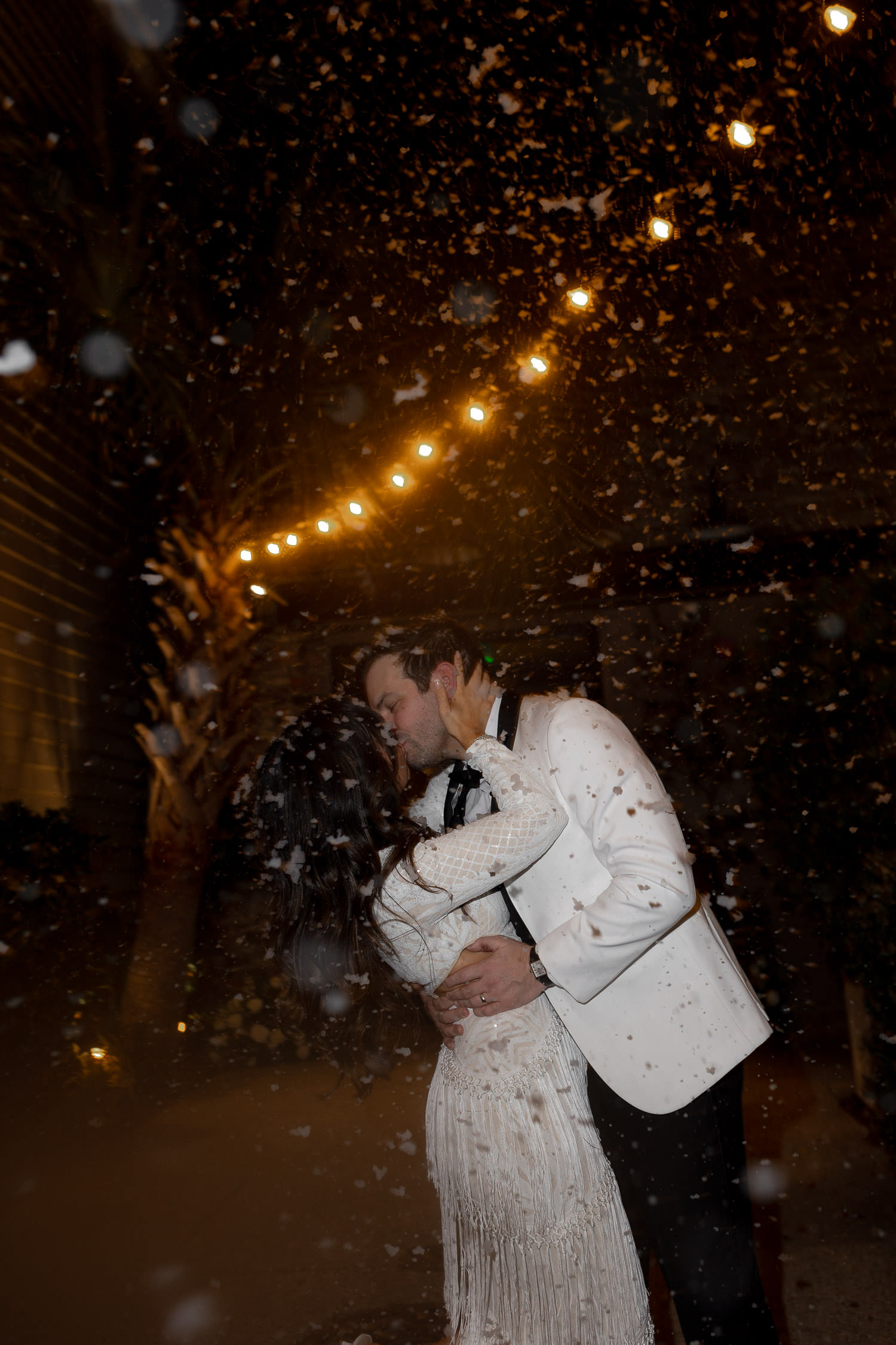 Let it snow. Bride and groom kissing while snowing.