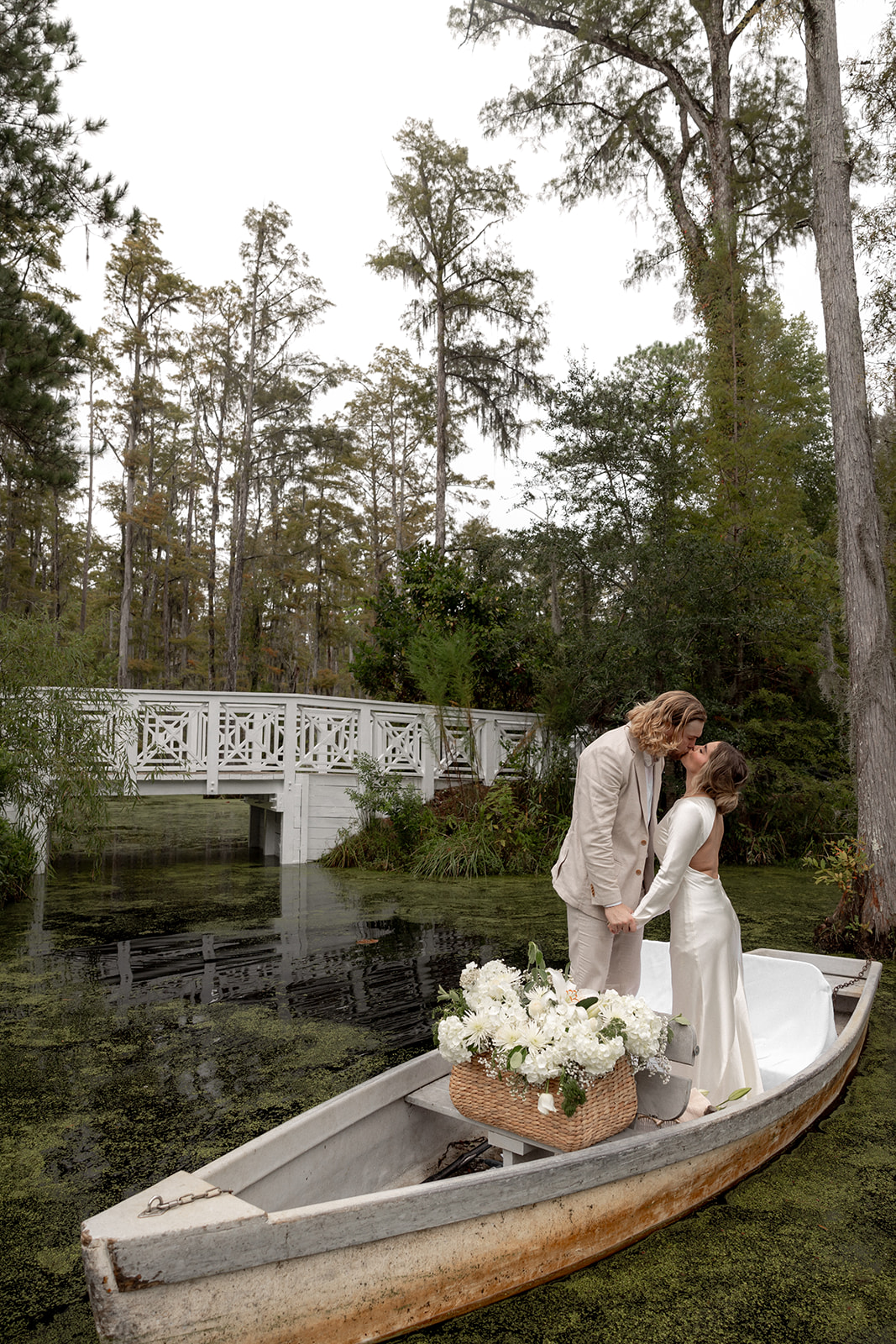 Couple standing in boat in the middle of blackwater swamp at cypress Gardens