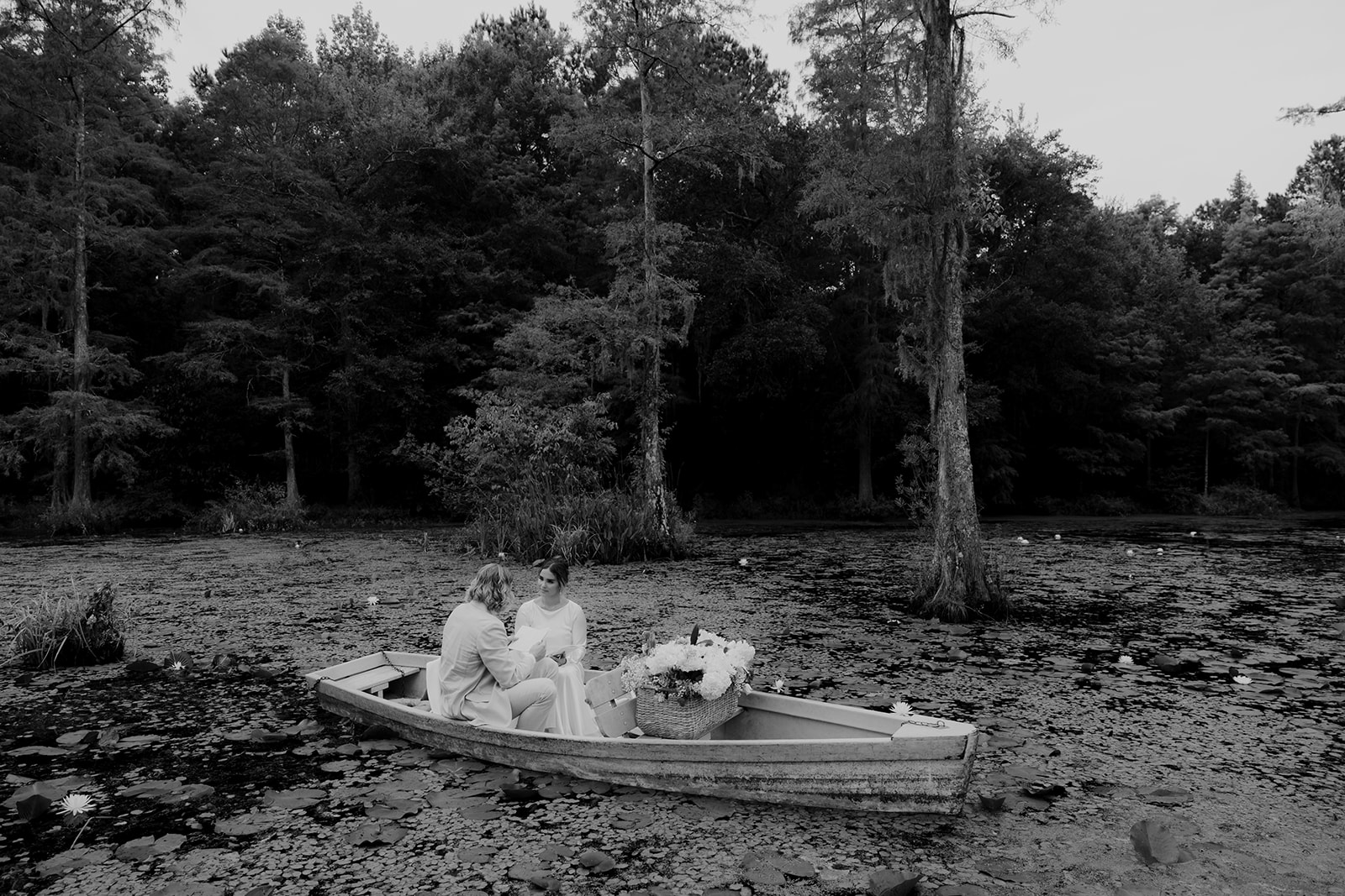 Black and white photo of couple exchaning private vows in serene swamp