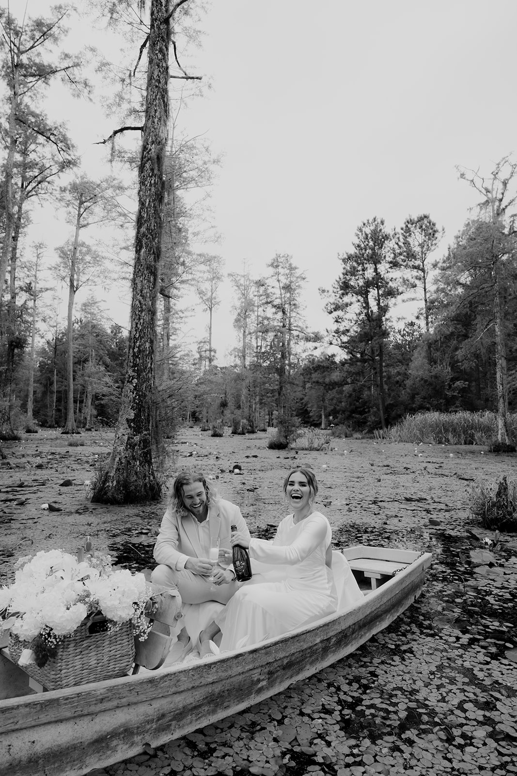 Couple opening a bottle of champagne at Cypress Gardens swamp