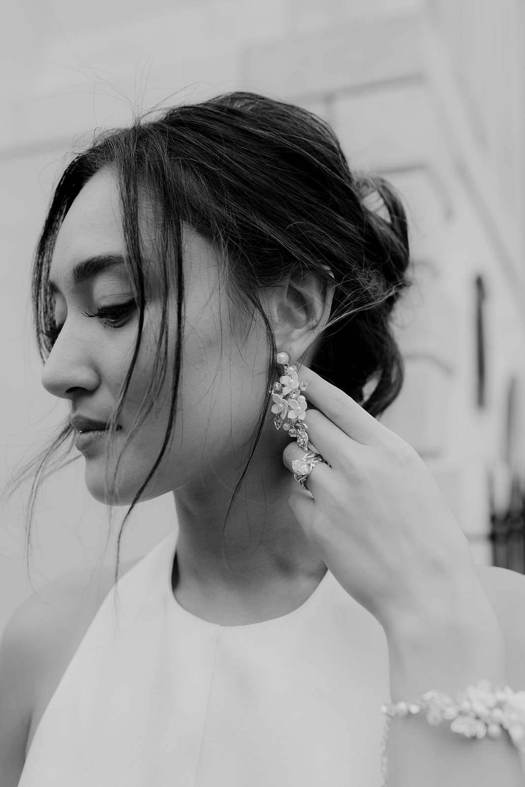 Woman showing earings turning her head to profile and lifting it with one hand. Adding to her Engagement photo Look