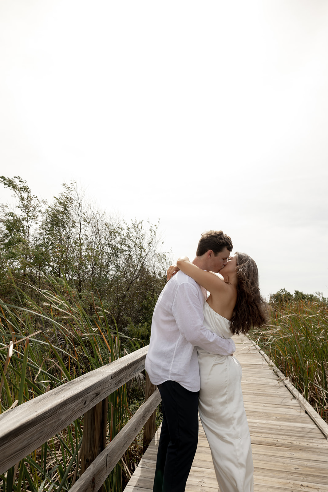 Couple kissing on wooden walkway on Isle of Palms for engagment photos