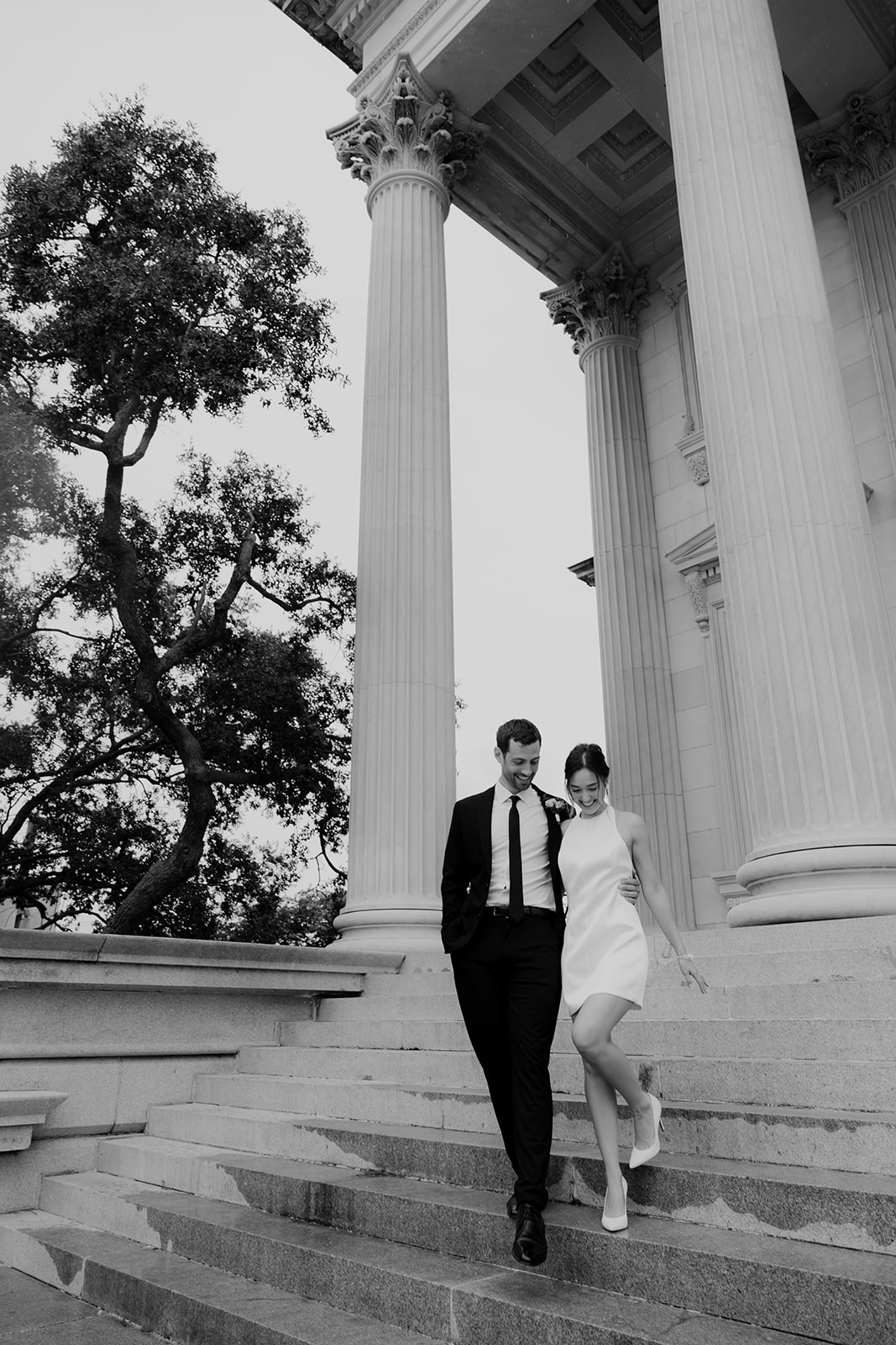 Couple walking downstairs side by side at US Custom building in stunning timeless Engagement Look