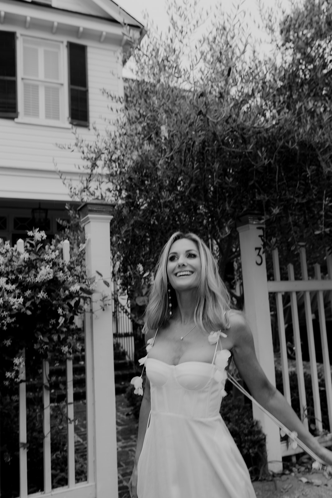 Woman in white dress enjoying life in Charleston. White fence in background