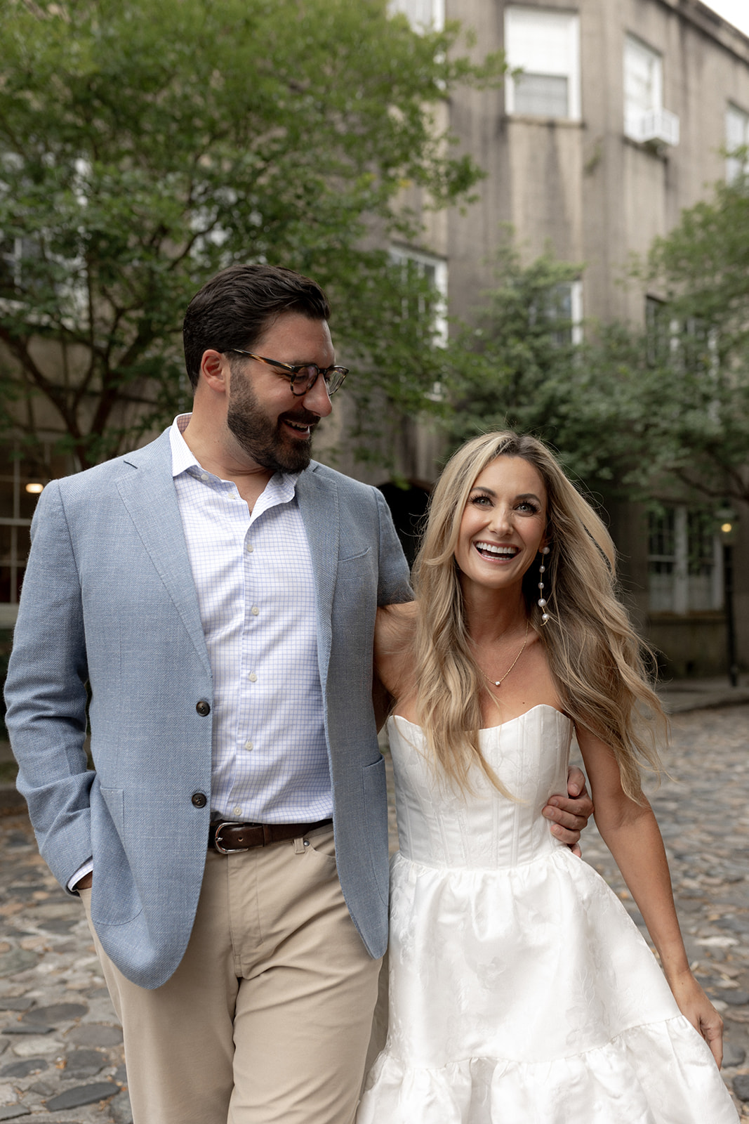 Couple walking on historic cobblestone street in CHarleston for Downtown Engagement photo session