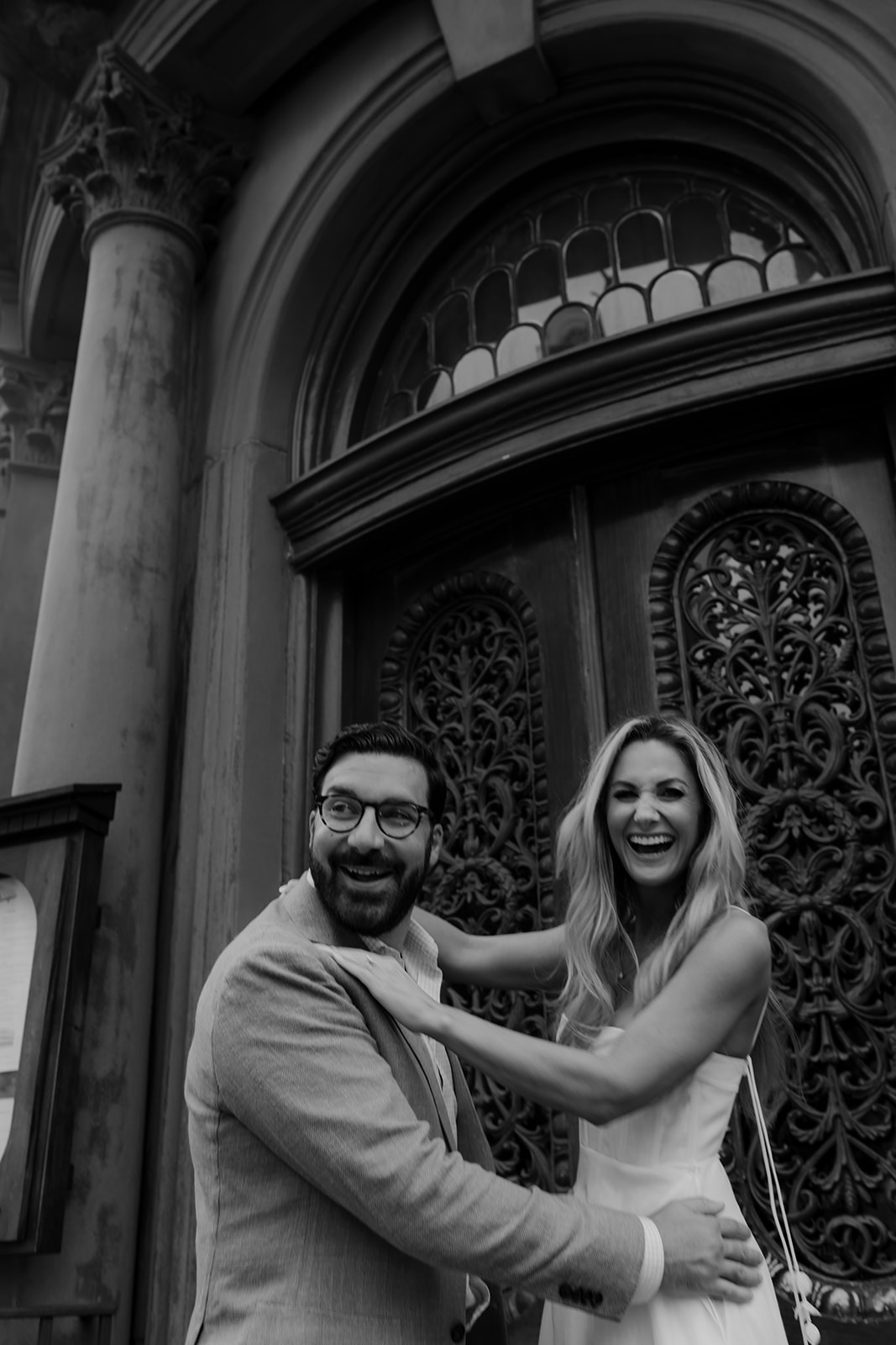 Couple having fun while taking photos in Charleston. Histroic door in background. 