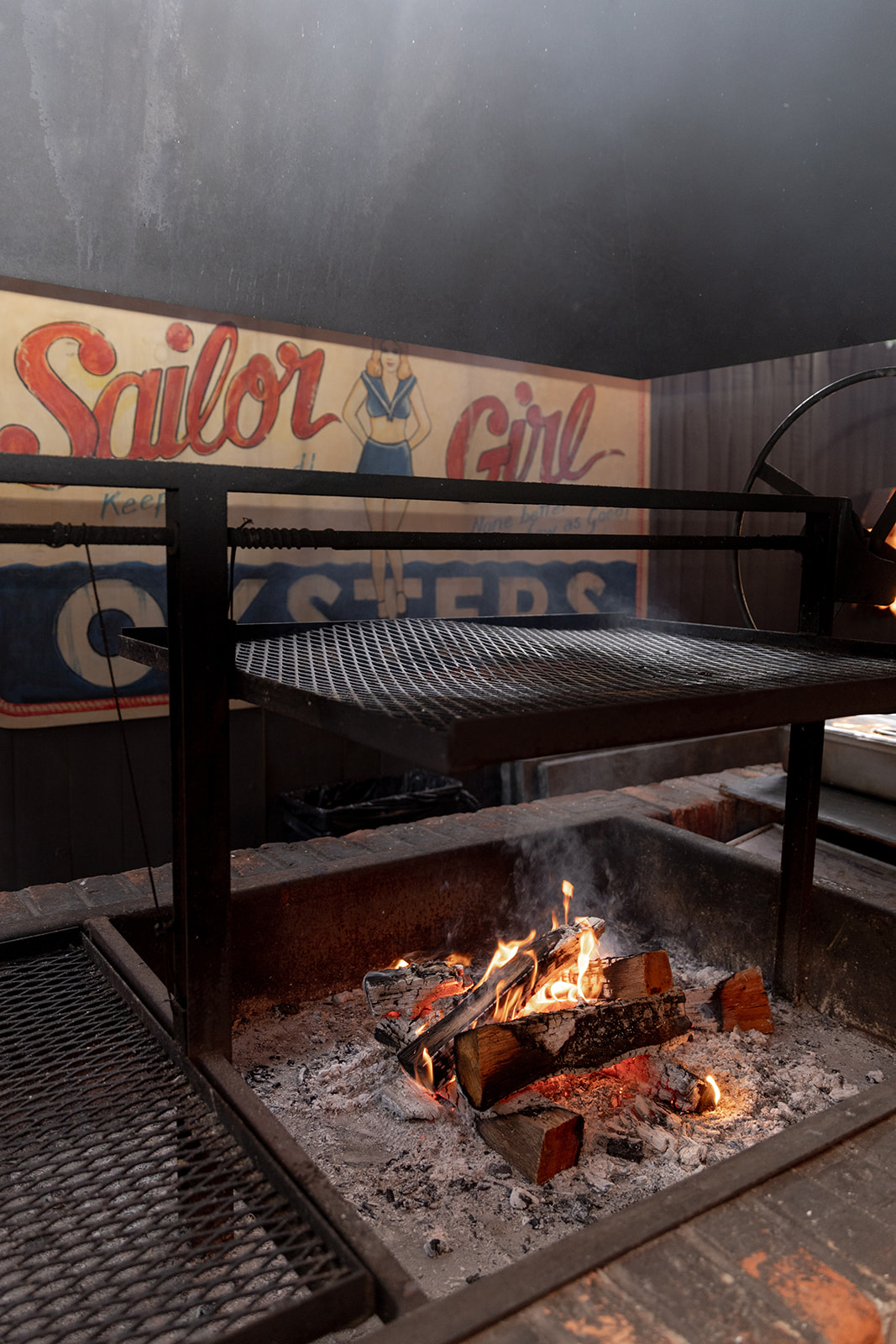 Open fire oyster roast and grill with retro sign in background