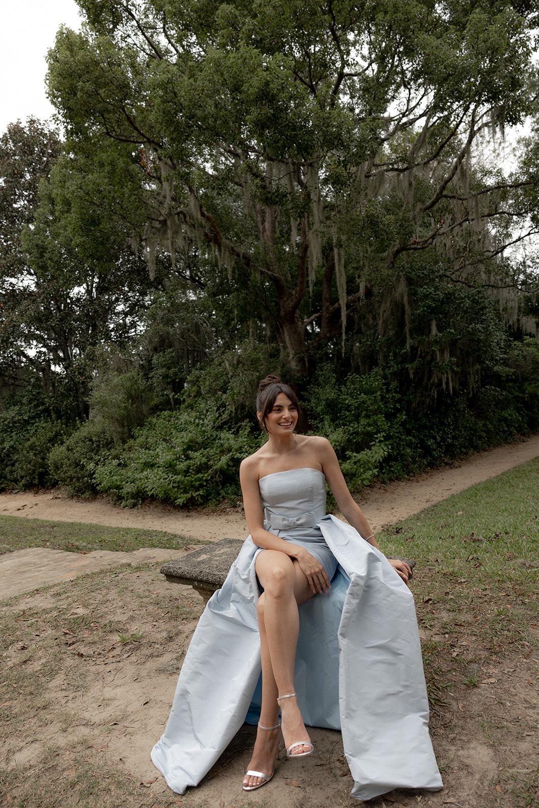 Paige deSorbo sitting on stone bench at Middleton Place Wedding