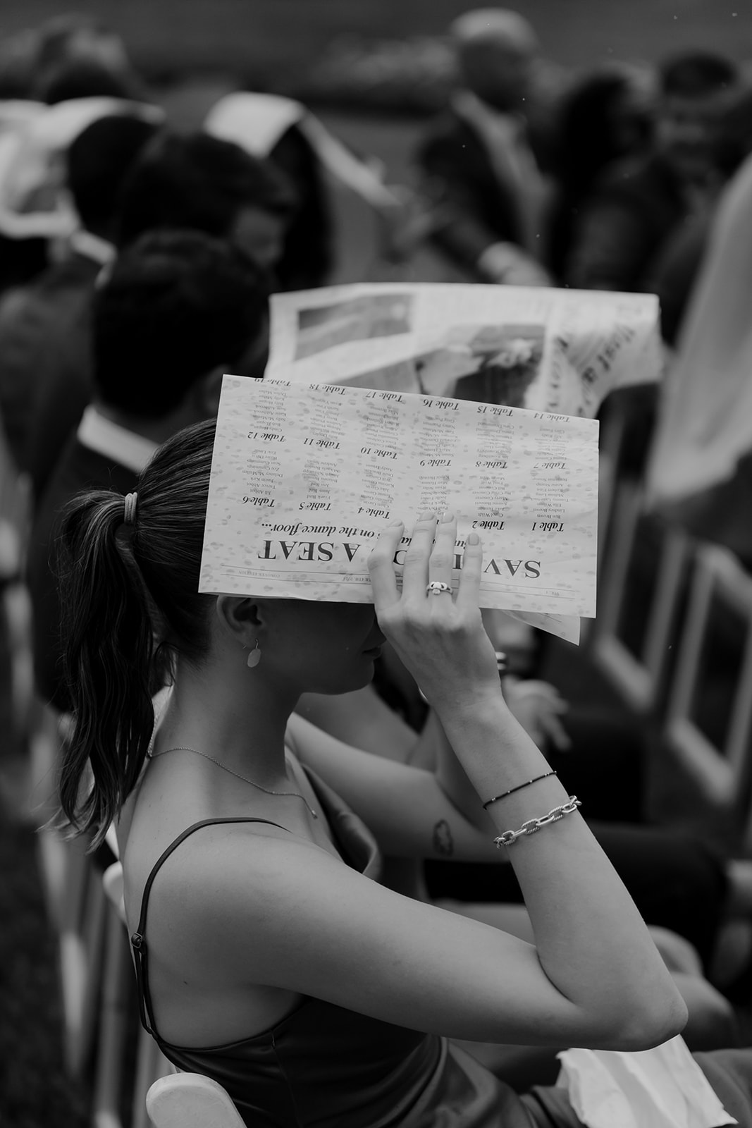 Wedding guests cover their heads with the wedding newspaper to get some protection from the rain