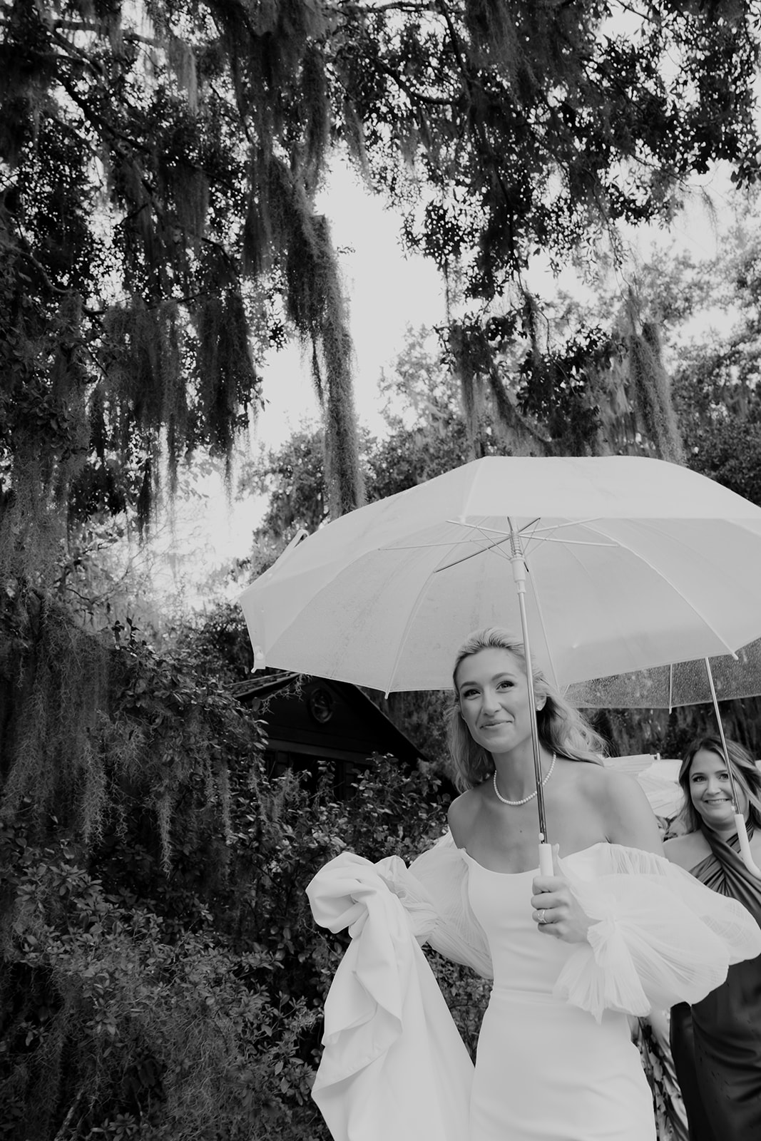 Bride holding umbrella and smiles into camera