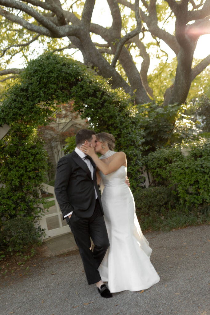 Wedding Couple kissing with greenery arch in background close to Post House Inn