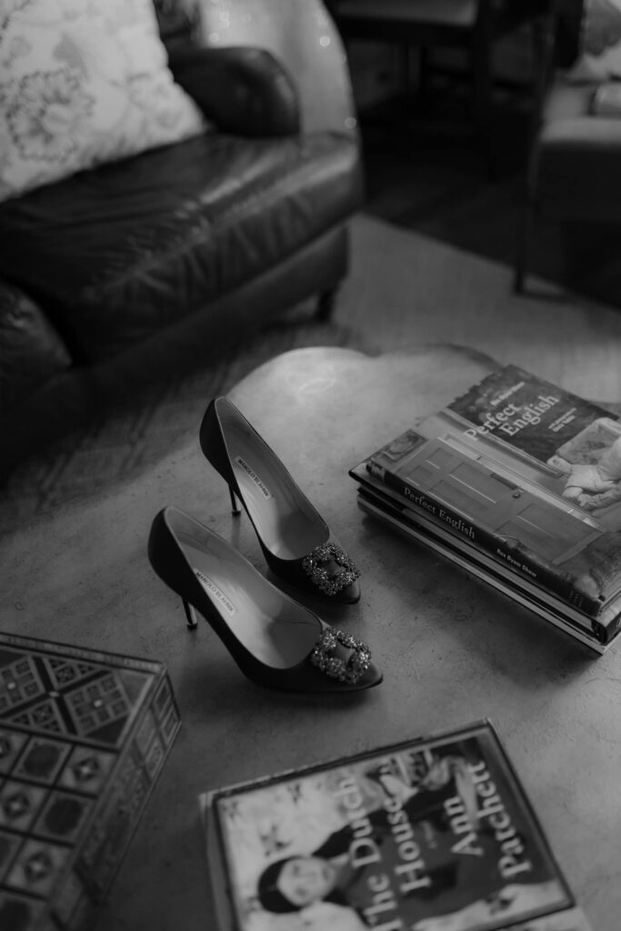 Bridal shoes in black and white on table next to table book