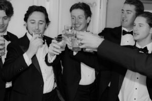 Groom having a drink with his groomsmen at wedding in Minnesota
