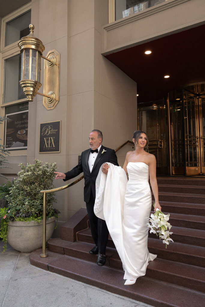 Father of the bride with his daugther walking downstairs at the hotel