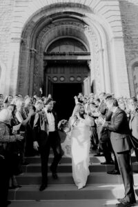 Exiting the Church Of The Assumption in St. Paul minneapolis as newlyweds. Guest and family standing left and right